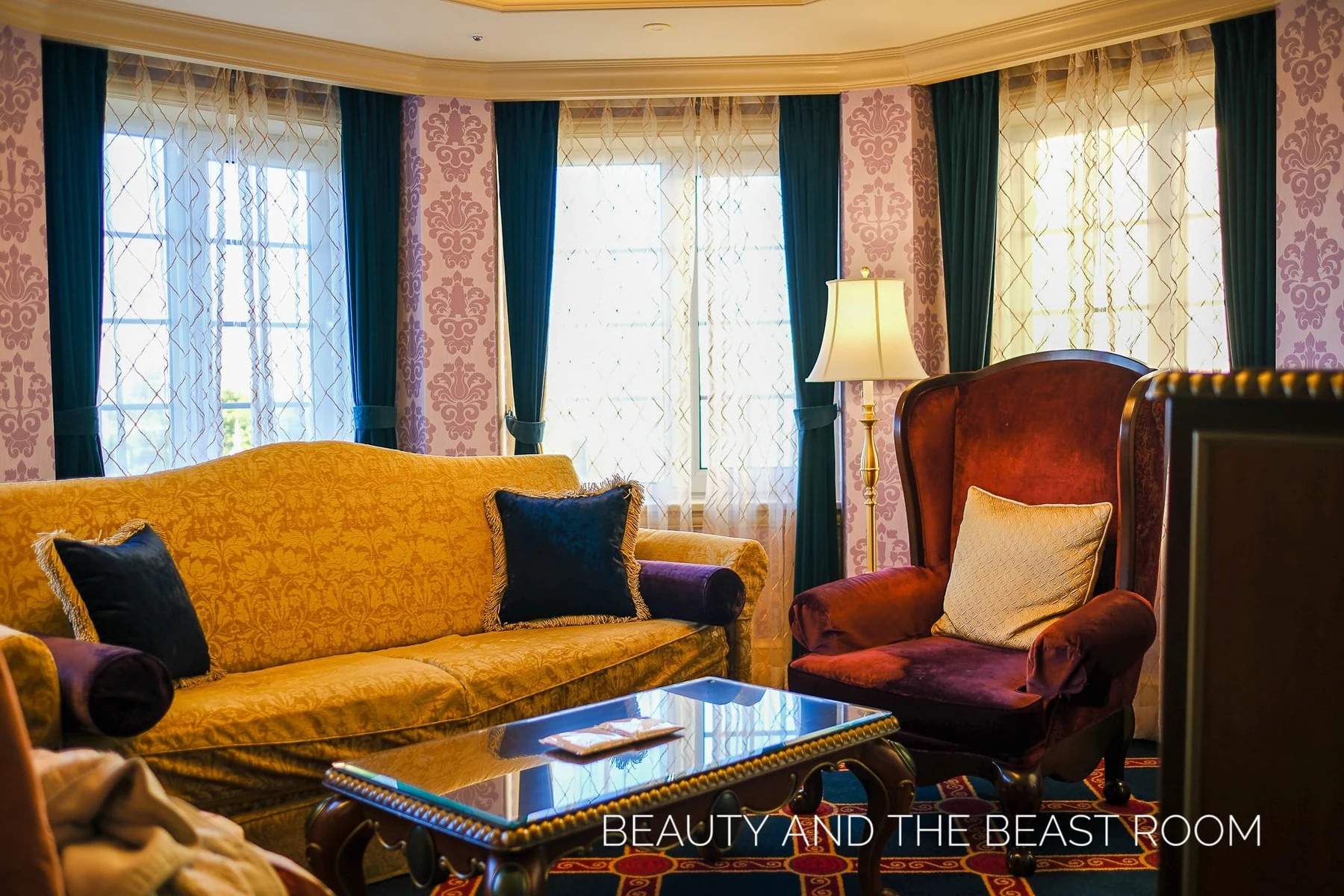 โซฟาสีเหลืองและเก้าอี้สีแดงในมุมนั่งเล่นของห้อง Beauty and the Beast