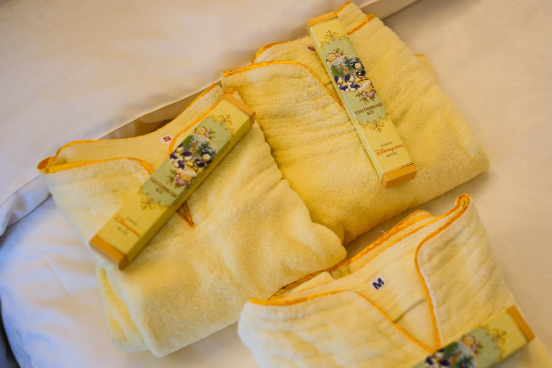 ชุดนอนสำหรับแขกของ Tokyo Disneyland Hotel พับวางอยู่บนเตียง