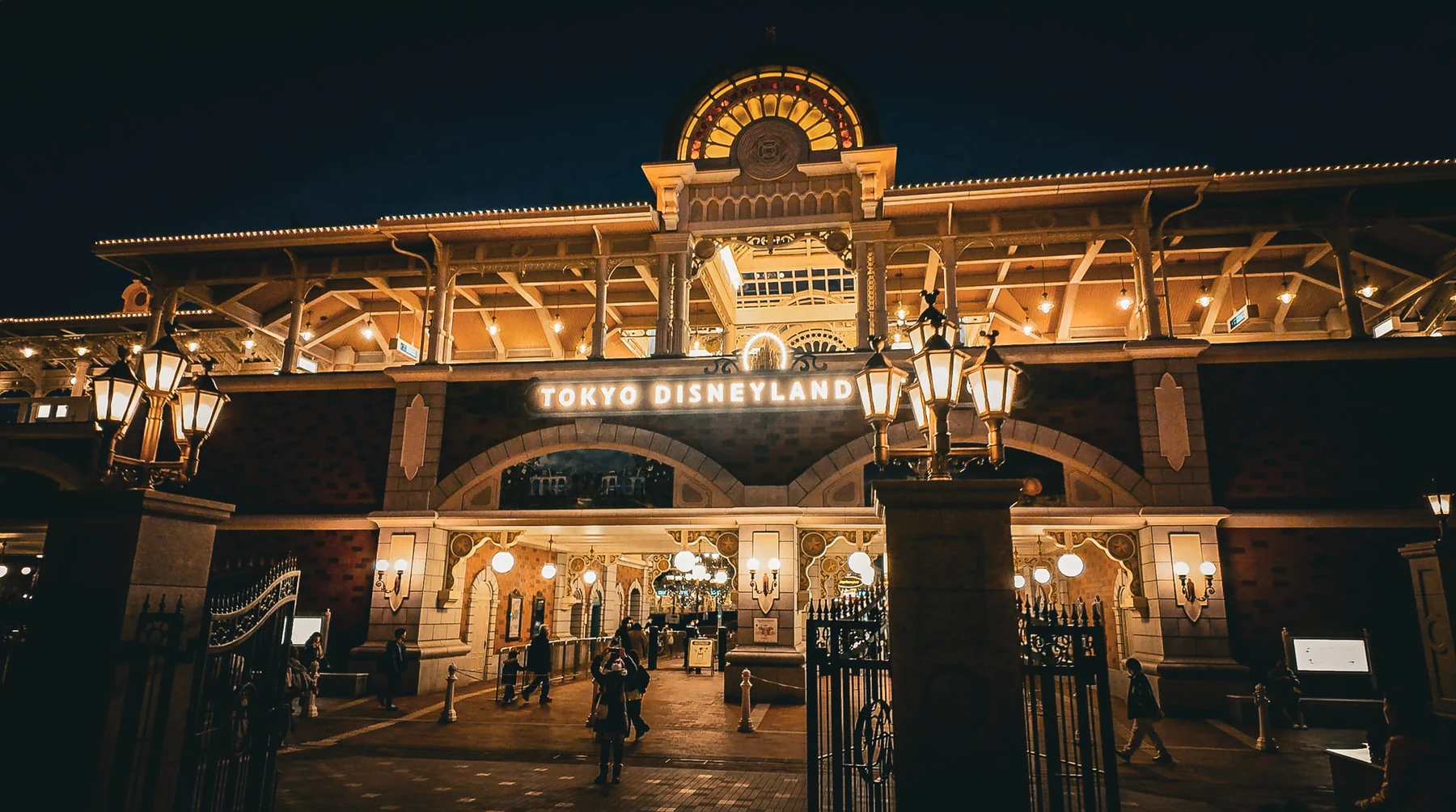 ทางเข้า Tokyo Disneyland และอาคาร World Bazaar เปิดไฟในช่วงค่ำ