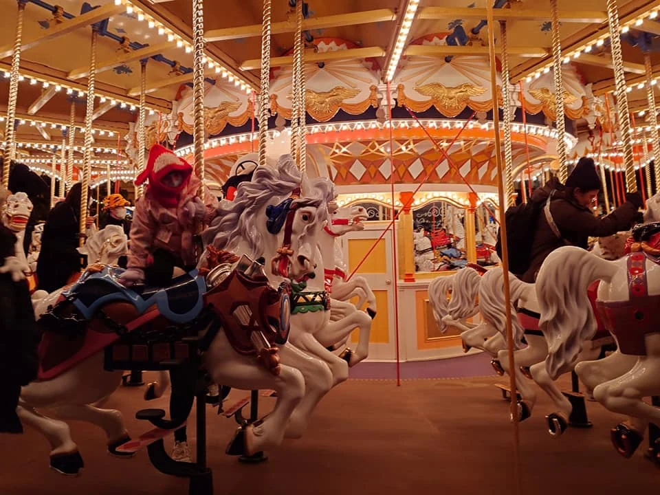 ม้าหมุนประดับไฟสีทองใน Tokyo Disneyland ตอนกลางคืน
