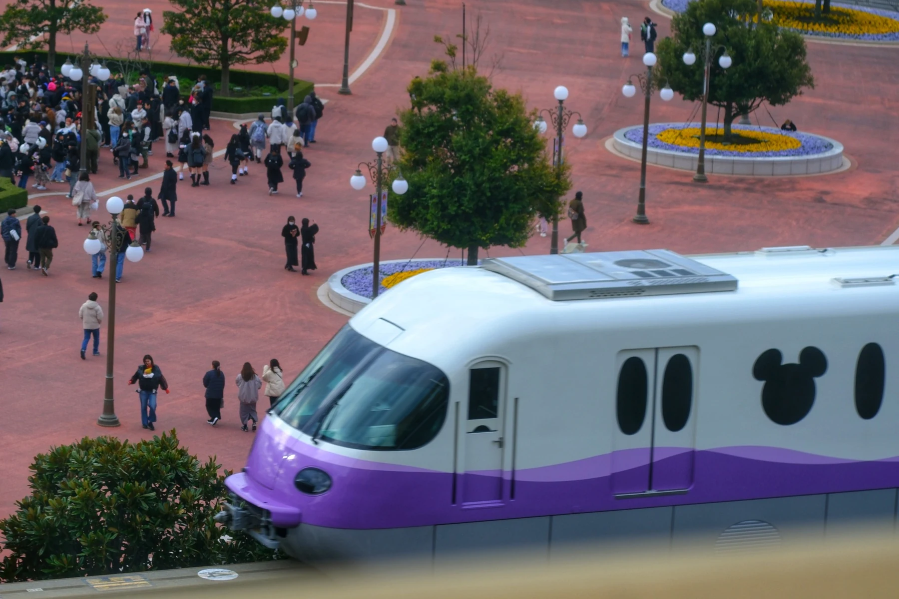 Monorail สีม่วงและผู้คนบริเวณลานหน้าสวนสนุก มองจากห้องพัก
