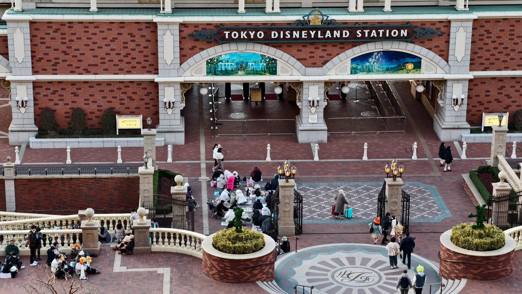 มองจากระเบียงลงไปยังทางเข้าสถานี Tokyo Disneyland และผู้คนที่รออยู่ด้านหน้า