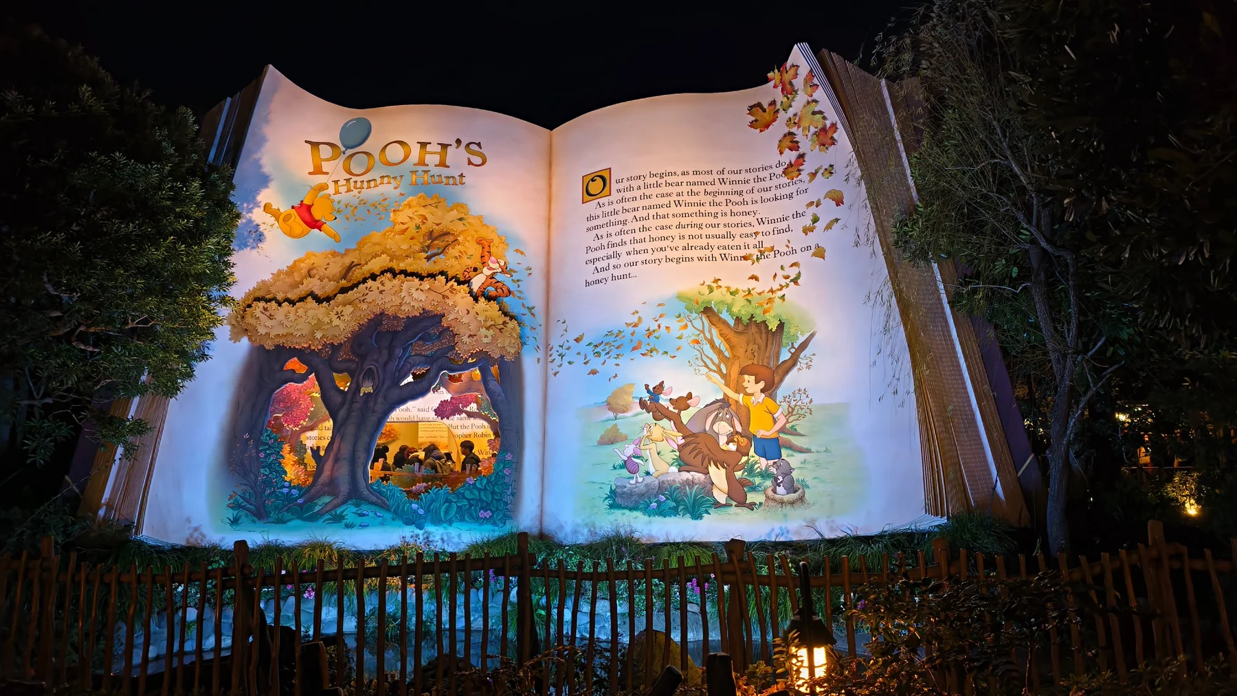 ป้ายหนังสือขนาดใหญ่หน้า Pooh’s Hunny Hunt ในเวลากลางคืน