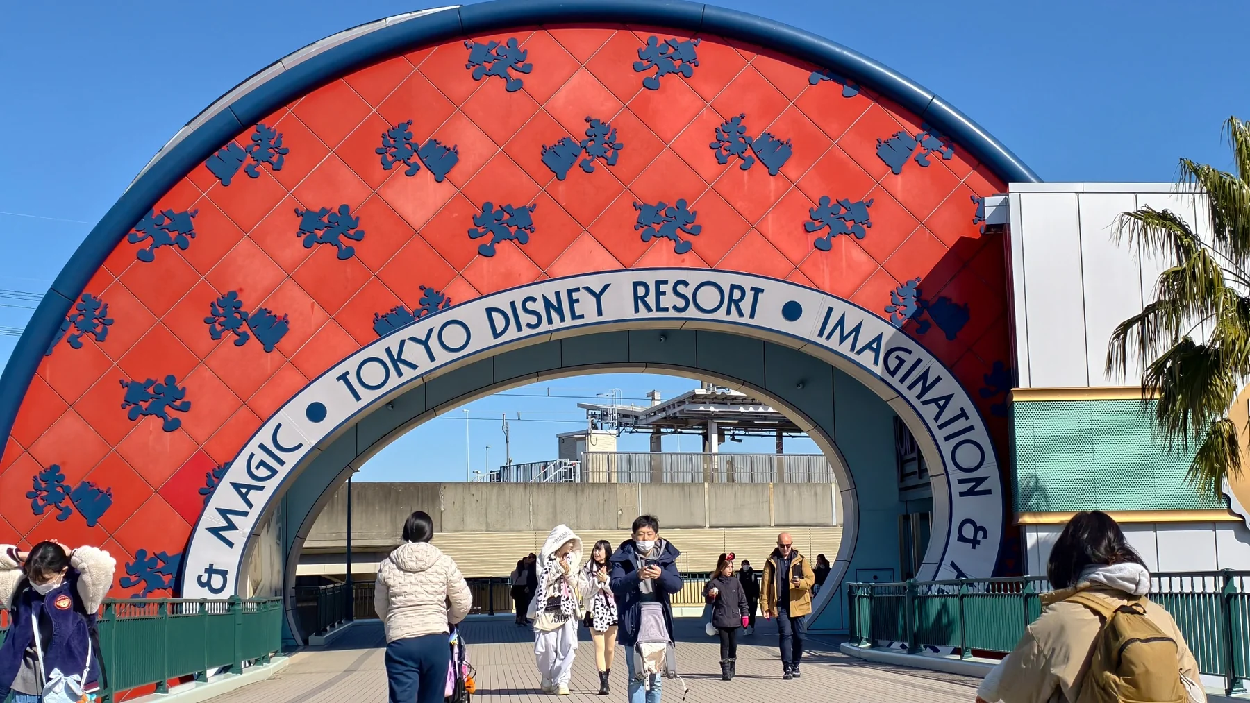 ผู้คนเดินผ่านซุ้ม Magic และ Imagination ของ Tokyo Disney Resort