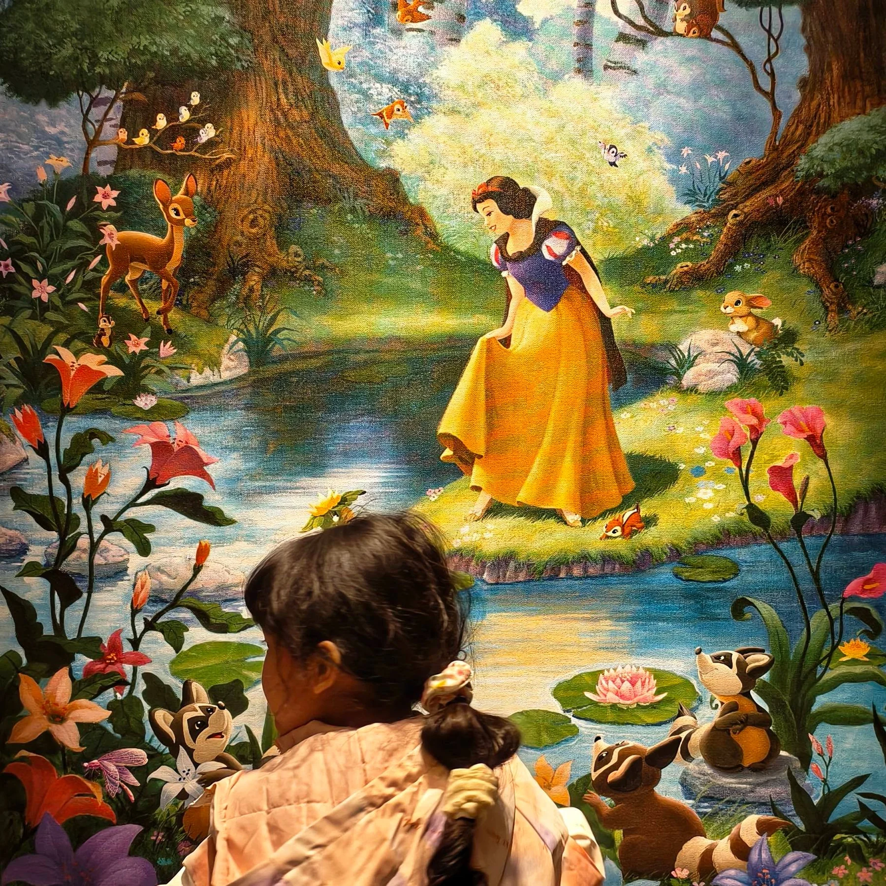 ลูกสาวมองภาพ Snow White บนผนังภายในโรงแรม