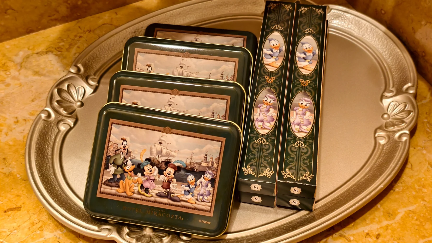 ชุดของใช้และกล่องลาย Disney บนถาดในห้องพัก