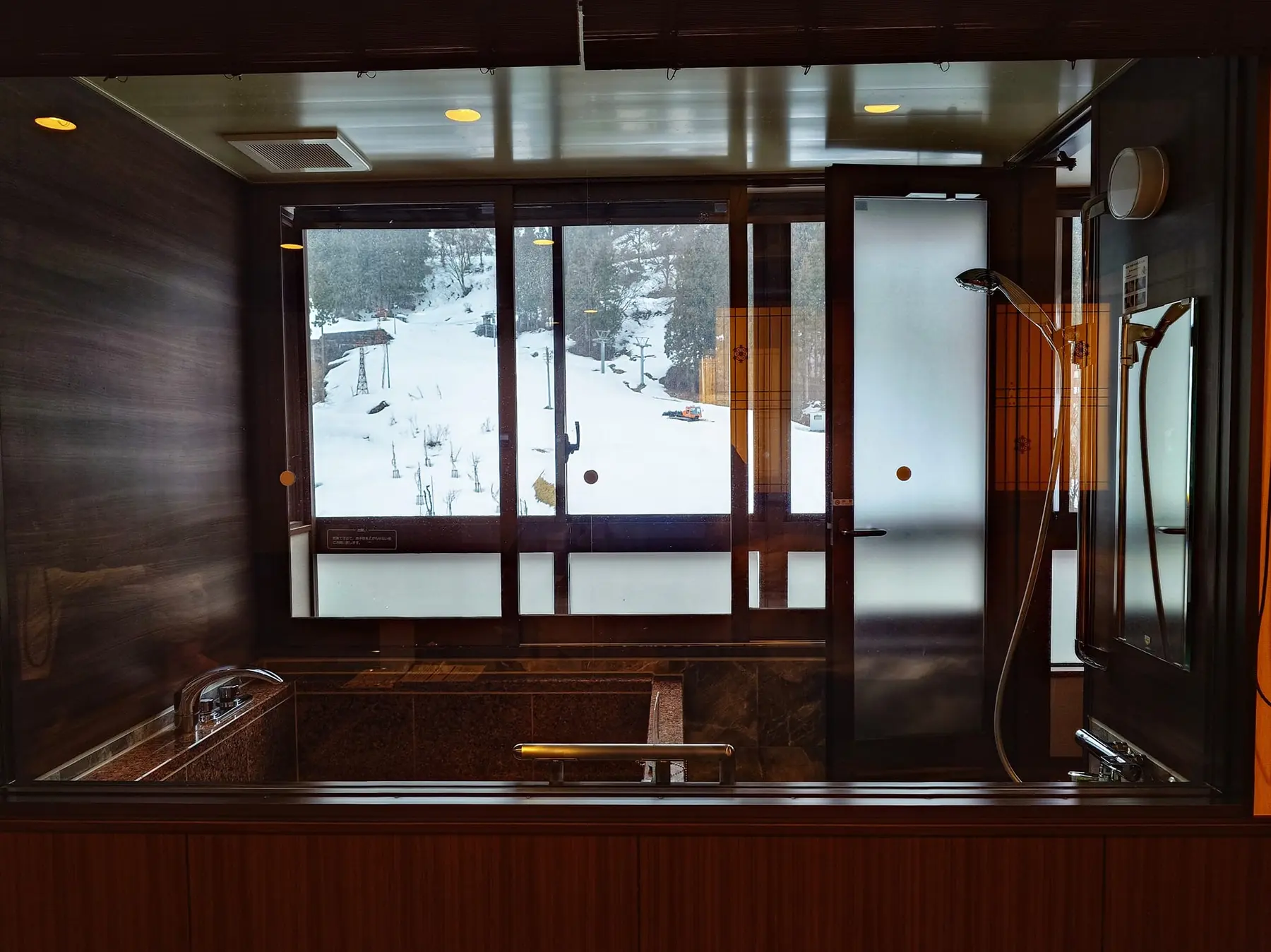 อ่างแช่น้ำในห้องแบบ semi open-air bath มองออกไปเห็นหิมะ